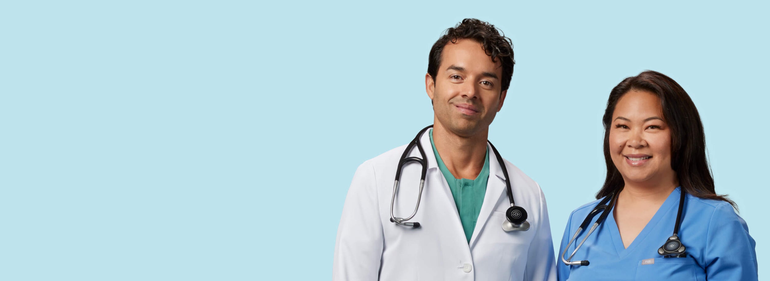 Two smiling clinicians wearing Eko CORE 500™ around their necks horizontal format