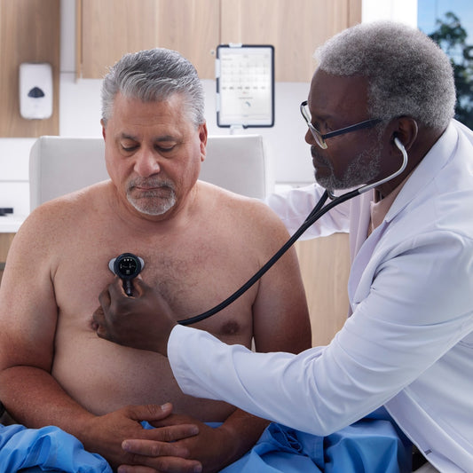 Doctor listens to older male patient's heart with a digital stethoscope
