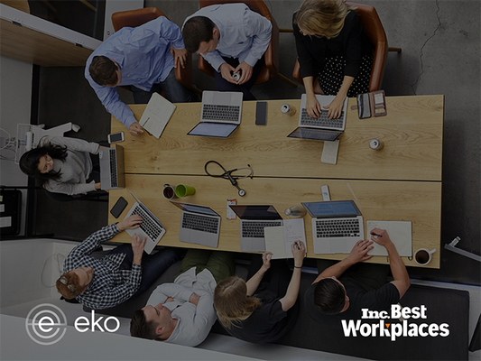 Group of office workers on laptops around a conference table