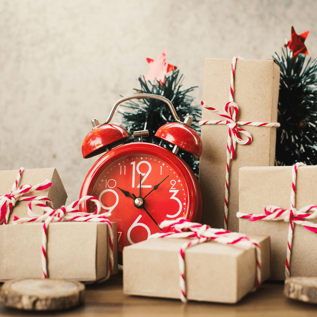 Red alarm clock among wrapped presents