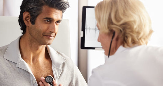 Doctor listening to heart sounds on patients chest using a 3M Littmann Core Digital Stethoscope 