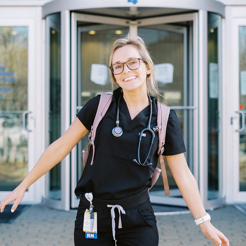 Young smiling nurse standing outside of building